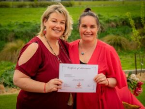 Two women holding the Red Tent Aotearoa completion certificate.